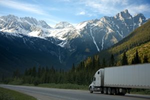 semi tractor and dry van trailer trucking with mountains in th background