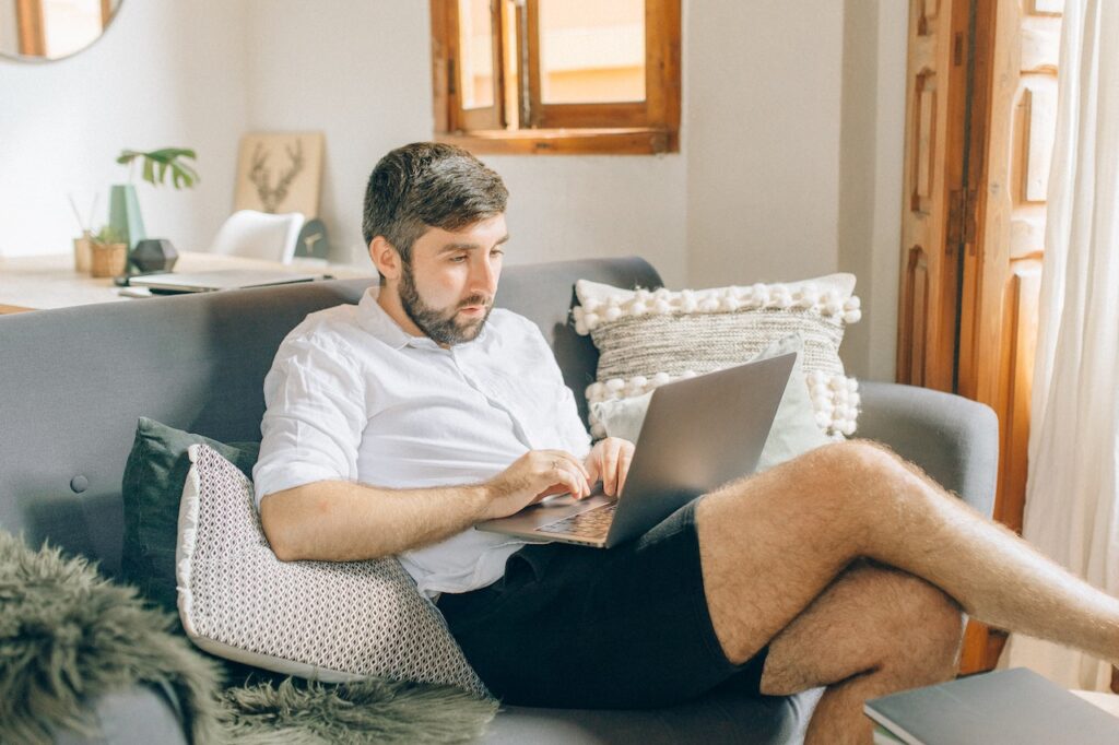 man using a laptop from his home office to check on a courier delivery in Indianapolis